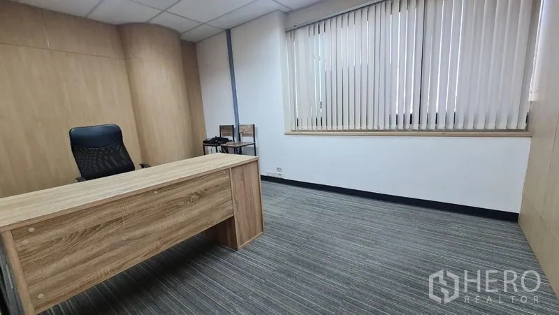 Office Space for rent in Watthana, Bangkok - Compact executive office with wood-paneled walls, desk and carpet flooring.
