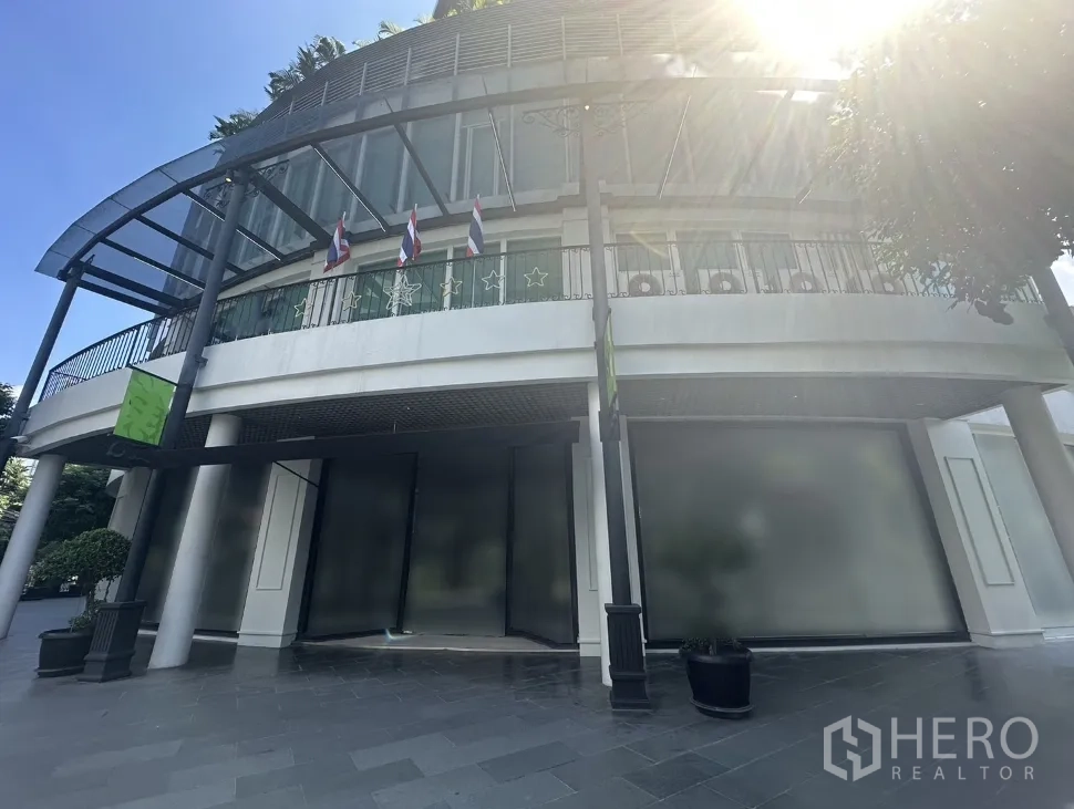 Office Space for rent in Khlong Toei, Bangkok - Curved modern building exterior with glass frontage, canopy and flags, ideal for an office entrance in Ekkamai.