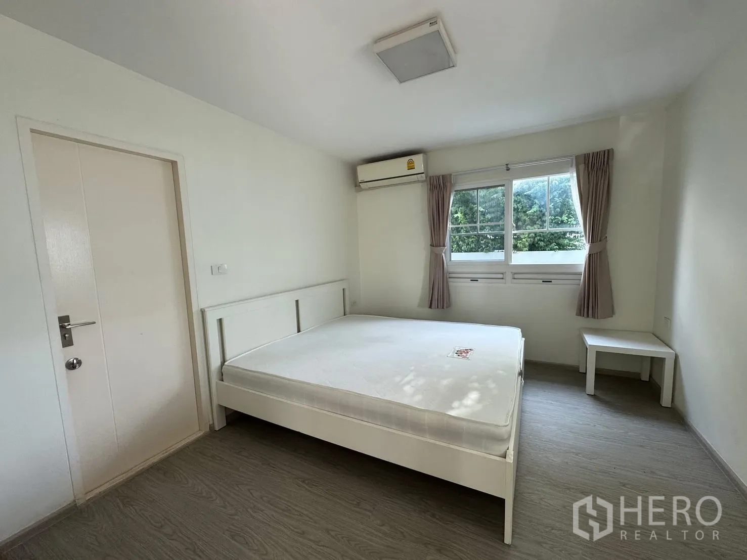 Detached House for rent in Bang Phli, Samut Prakan - Bedroom with bed frame, air conditioner, window and bedside table.