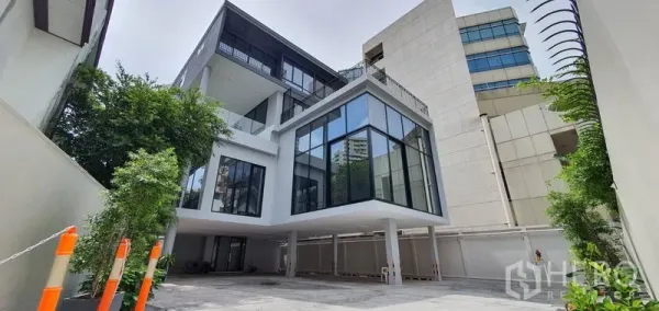 Home Office for rent or sale in Watthana, Bangkok - Contemporary glass‑fronted home office building with driveway and greenery.