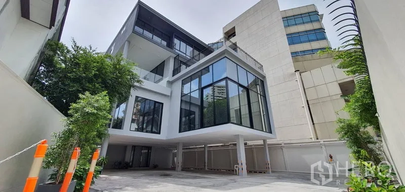 Home Office for rent or sale in Watthana, Bangkok - Contemporary glass‑fronted home office building with driveway and greenery.