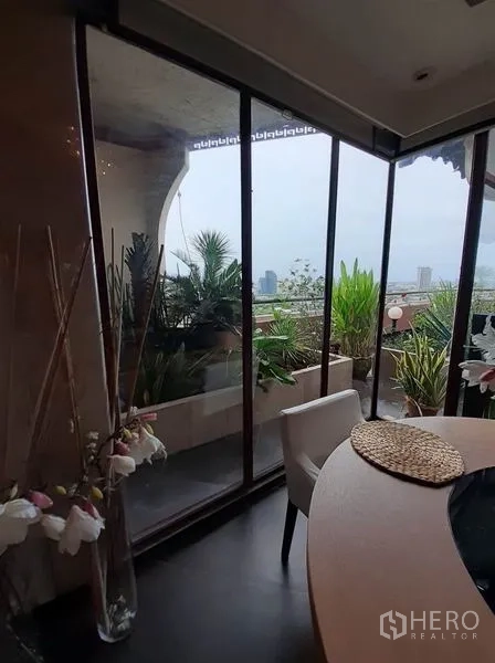 公寓 出租在Bang Na, Bangkok - 餐桌旁落地玻璃面对露台花园与天际线