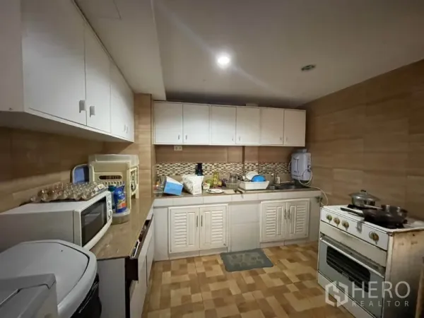 ทาวน์เฮาส์ ขายในKhlong Toei, Bangkok - ครัวใช้งานสะดวก ตู้บิลท์อินสีขาว ผนังกระเบื้อง ซิงก์ และเตาแก๊สตั้งพื้น