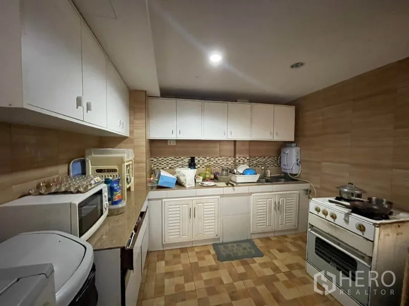 ทาวน์เฮาส์ ขายในKhlong Toei, Bangkok - ครัวใช้งานสะดวก ตู้บิลท์อินสีขาว ผนังกระเบื้อง ซิงก์ และเตาแก๊สตั้งพื้น