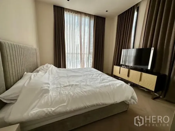 公寓 出租 - 卧室设转角大窗与遮光窗帘，床对面摆放电视柜。