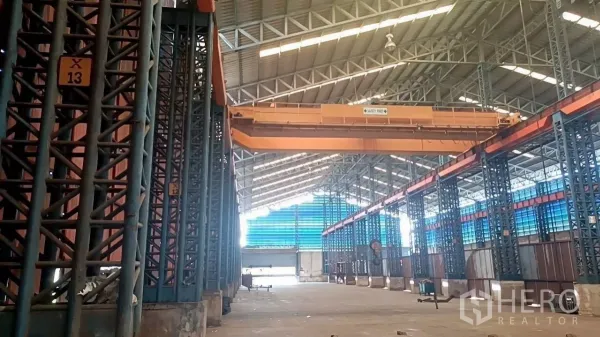 คลังสินค้า ให้เช่าในMueang Samut Sakhon, Samut Sakhon - โกดังอุตสาหกรรมพร้อมเครนโอเวอร์เฮดสีส้ม เสาโครงเหล็กเลขบอกช่อง และหลังคาสูงโปร่ง