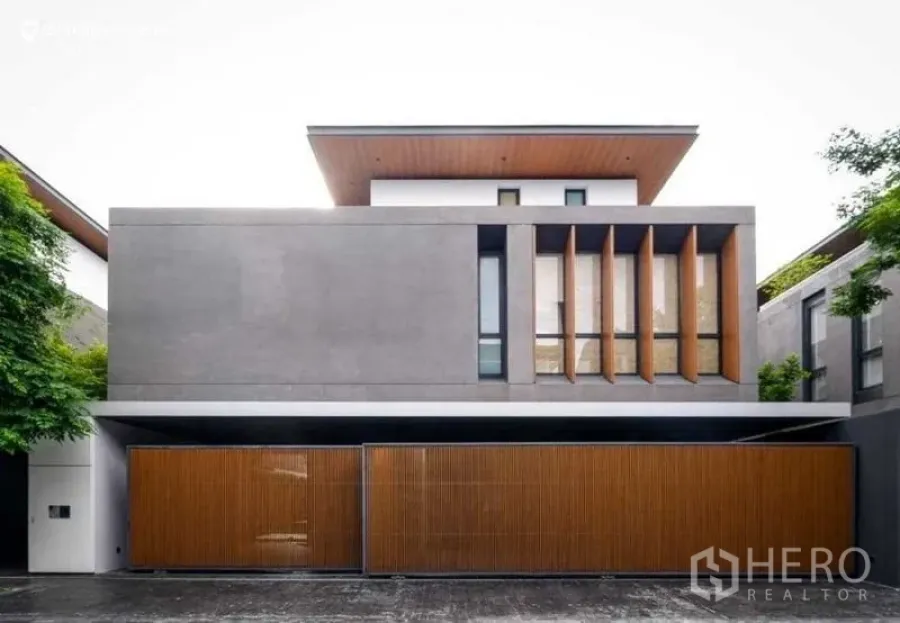 บ้าน ขายในHuai Khwang, Bangkok - ด้านหน้าบ้านสมัยใหม่ พร้อมประตูบานระแนงไม้และครีบแนวตั้ง