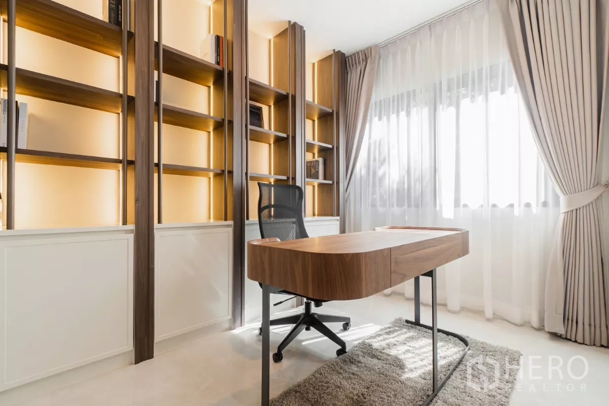 บ้าน ให้เช่าหรือขายในPrawet, Bangkok - ห้องทำงานมีชั้นวางหนังสือไฟซ่อน โต๊ะไม้ และหน้าต่างบานใหญ่