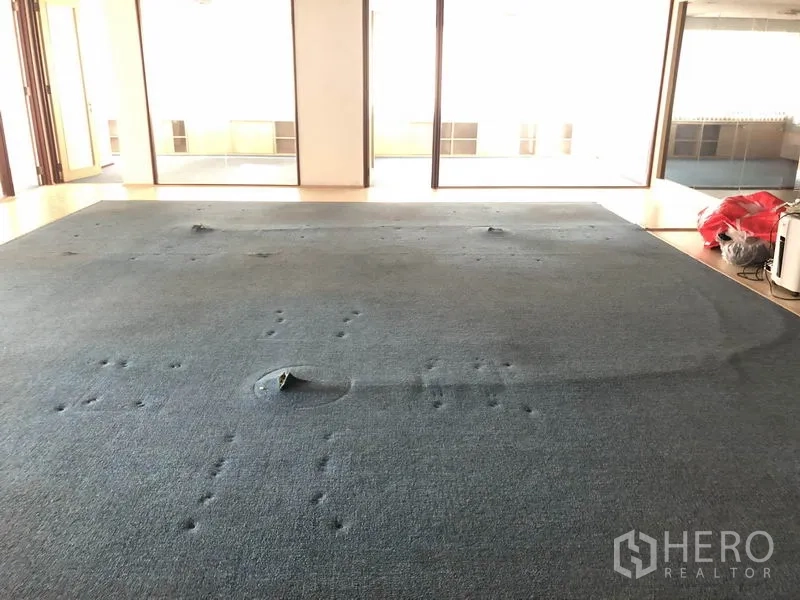 办公空间 出租在Watthana, Bangkok - 铺地毯的开放办公区，地面插座与玻璃隔断可见