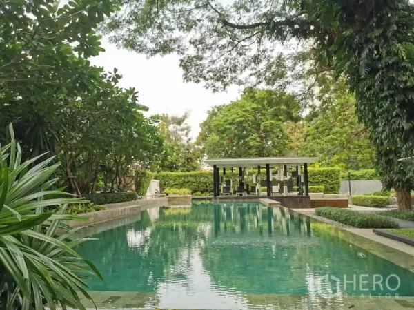 公寓 出租在Watthana, Bangkok - 度假风户外泳池，周围环绕绿植与凉亭。