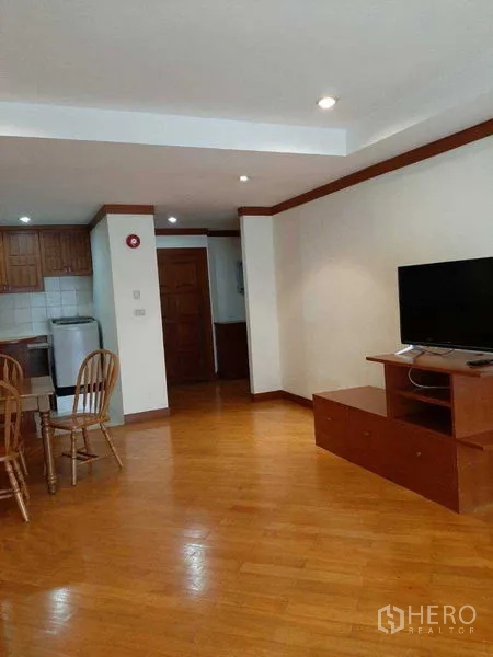 อพาร์ทเมนท์ ให้เช่าในWatthana, Bangkok - ห้องนั่งเล่นกว้าง พร้อมชั้นวางทีวี มองไปยังโต๊ะทานอาหารและครัว