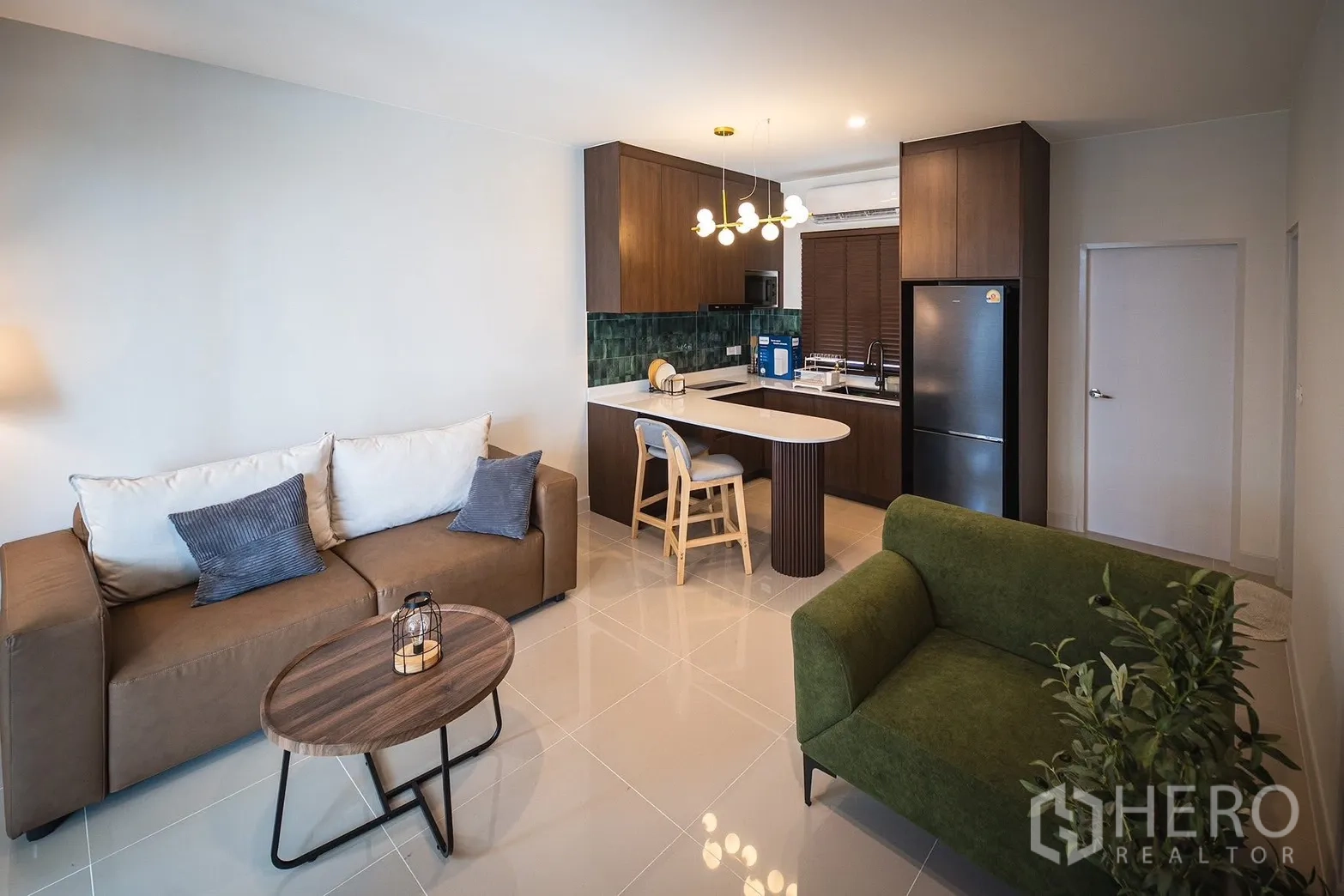 联排别墅 for rent in Bang Phli, Samut Prakan - 开放式客厅与现代厨房，配岛台和沙发。