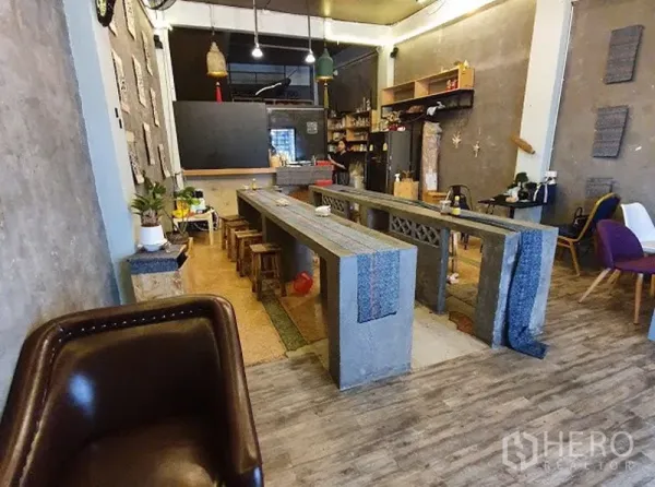 店屋 出租在Watthana, Bangkok - 工业风店屋内景，长条混凝土餐台、吊灯、开放式备餐台与木地板，位于曼谷瓦他那。