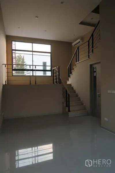 ทาวน์เฮาส์ ให้เช่าในSuan Luang, Bangkok - โถงรับแขกสไตล์ชั้นลอย พร้อมบันไดราวเหล็กและหน้าต่างบานใหญ่