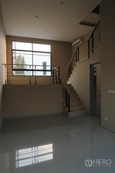 ทาวน์เฮาส์ ให้เช่าในSuan Luang, Bangkok - โถงรับแขกสไตล์ชั้นลอย พร้อมบันไดราวเหล็กและหน้าต่างบานใหญ่