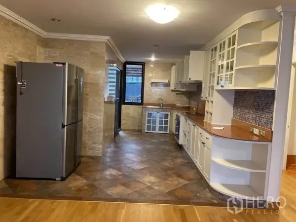 คอนโด ให้เช่าในWatthana, Bangkok - ครัวตัวแถวตู้สีขาว แบ็กสแพลชโมเสก และเตาอบบิวท์อินใกล้หน้าต่าง