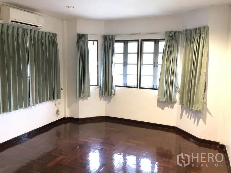 Detached House for rent - Corner bedroom with bay windows, multiple panes and green curtains.