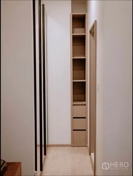 Condominium for sale in Huai Khwang, Bangkok - Detail of slim wooden shelving tower with drawers providing extra storage.