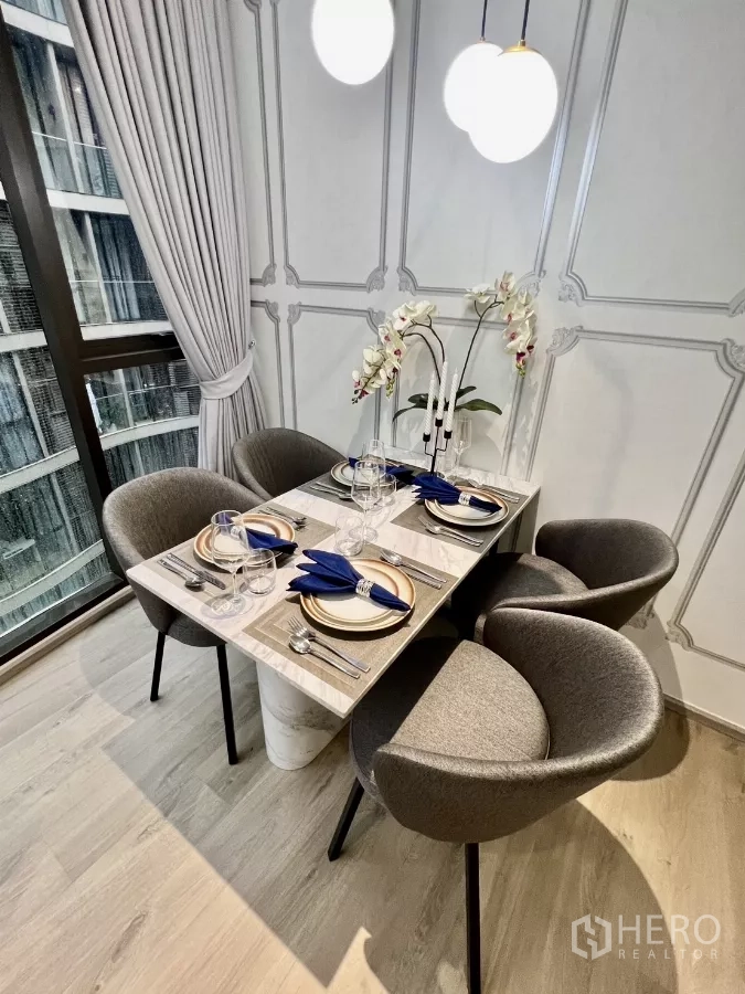 คอนโด ให้เช่าในKhlong Toei, Bangkok - โต๊ะอาหารท็อปหินอ่อน จัดที่นั่ง 4 ที่ พร้อมโคมแขวนและเก้าอี้สีเทา