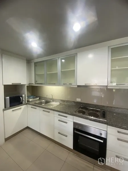 คอนโด ให้เช่าในWatthana, Bangkok - ครัวรูปตัวแอล เคาน์เตอร์หินแกรนิต เตาอบ เตาไฟฟ้า อ่างล้างจาน ไมโครเวฟ