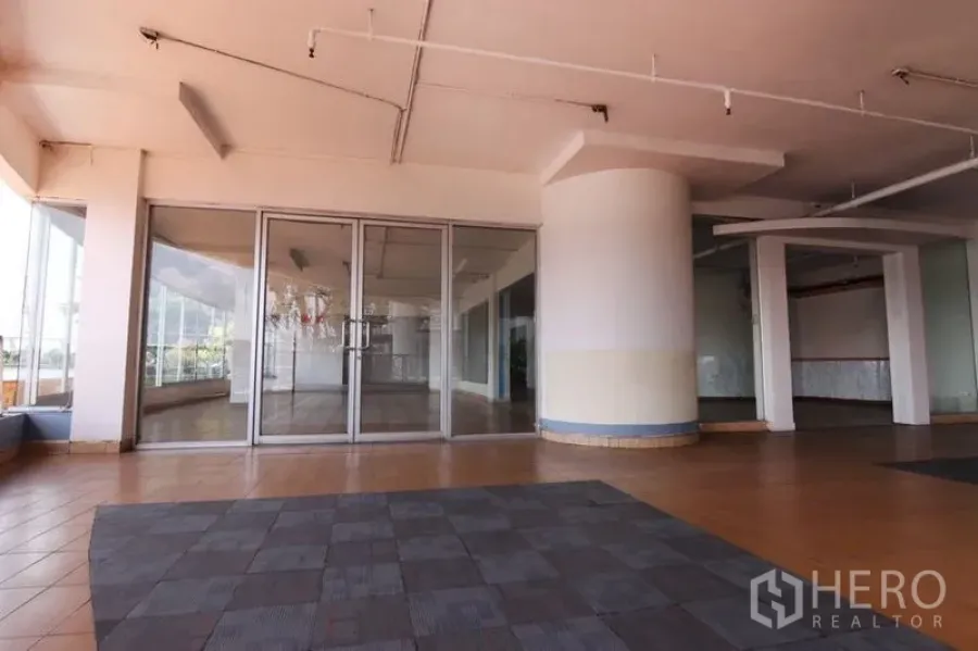 零售空间 出租在Yan Nawa, Bangkok - 店面入口设弧形立柱与大面积玻璃立面，外侧为遮蔽式平台。