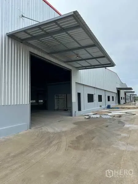 工厂 出租在Rayong - 罗勇府尼空帕塔纳新建工厂外观，带大型装卸雨棚与宽阔混凝土车道。