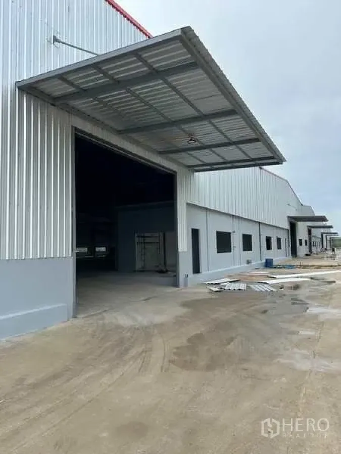 工厂 出租在Rayong - 罗勇府尼空帕塔纳新建工厂外观，带大型装卸雨棚与宽阔混凝土车道。