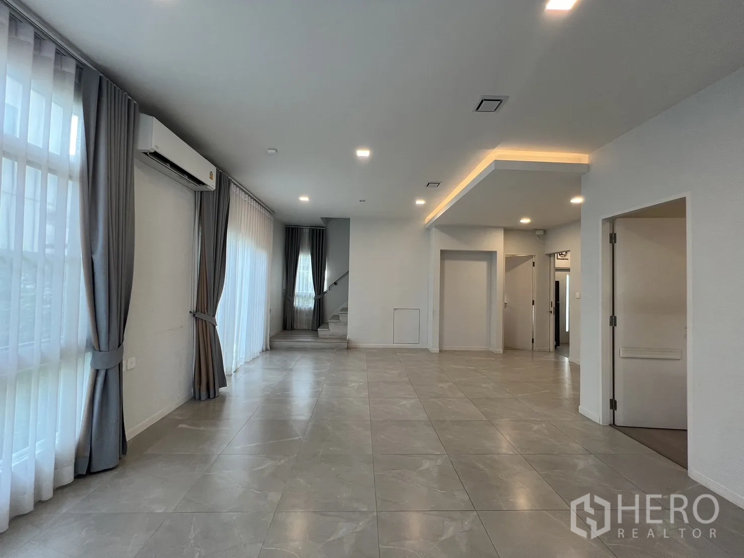 独立式住宅 出租在Prawet, Bangkok - 修长客厅通往楼梯与通庭院的滑门。