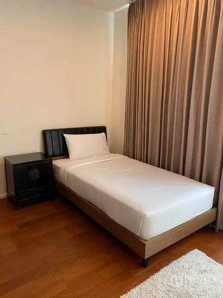 Condominium for rent in Watthana, Bangkok - Cozy single bedroom with wooden floor, single bed, bedside table, and full-length curtains.