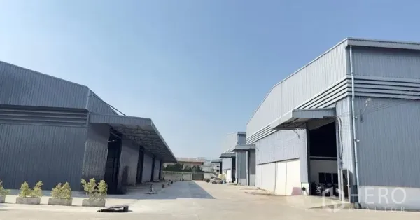 货栈 出租在Pathum Thani - 工业园区通道与多栋仓库立面，宽转弯半径适合货车。