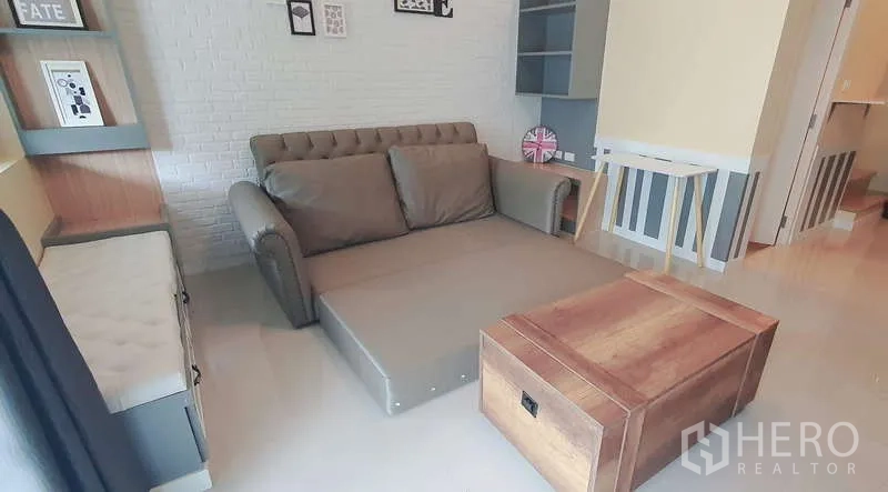 独立式住宅 出租在Bang Phli, Samut Prakan - 客厅沙发展开成床，配木箱式茶几。