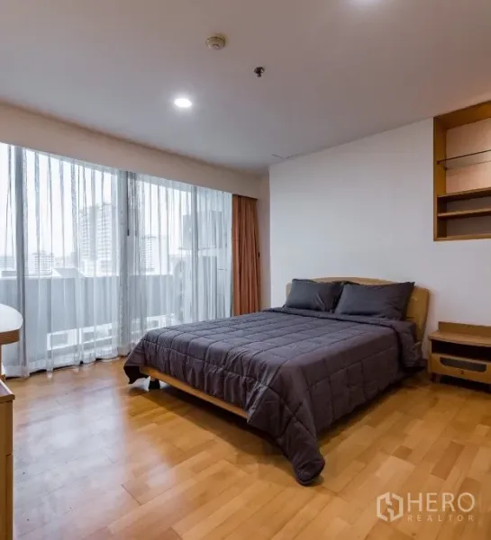 Condominium for rent or sale in Pathum Wan, Bangkok - Bright bedroom with floor-to-ceiling windows, balcony city view, and a queen bed.