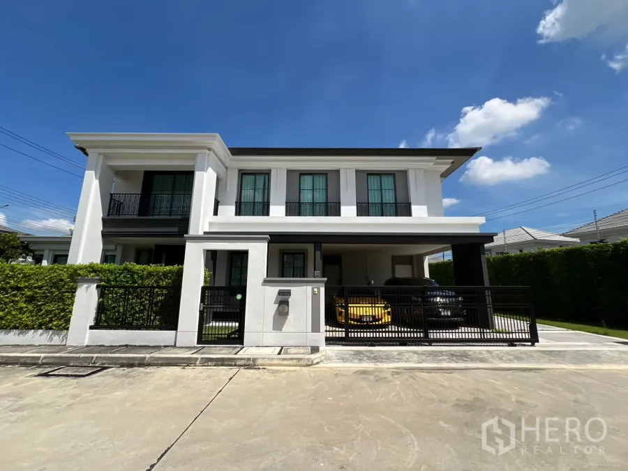 Detached House for rent or sale in Mueang Pathum Thani, Pathum Thani - Front exterior of a modern two-storey detached house with gated carport for two cars.