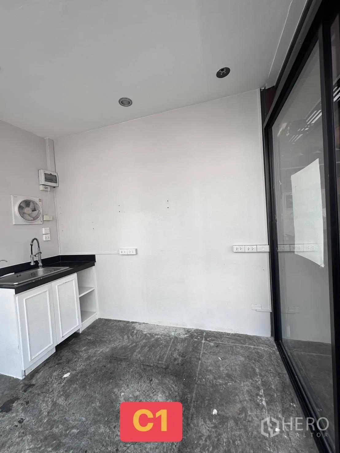 Retail Space for rent in Watthana, Bangkok - Interior corner showing black countertop with stainless sink, white cabinet, and power outlets.