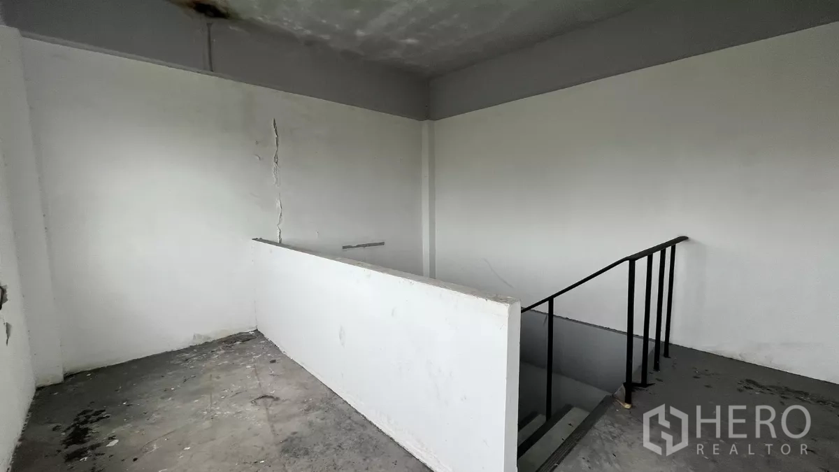 店屋 出租在Watthana, Bangkok - 上层楼梯平台，半高墙及可见墙体裂缝。