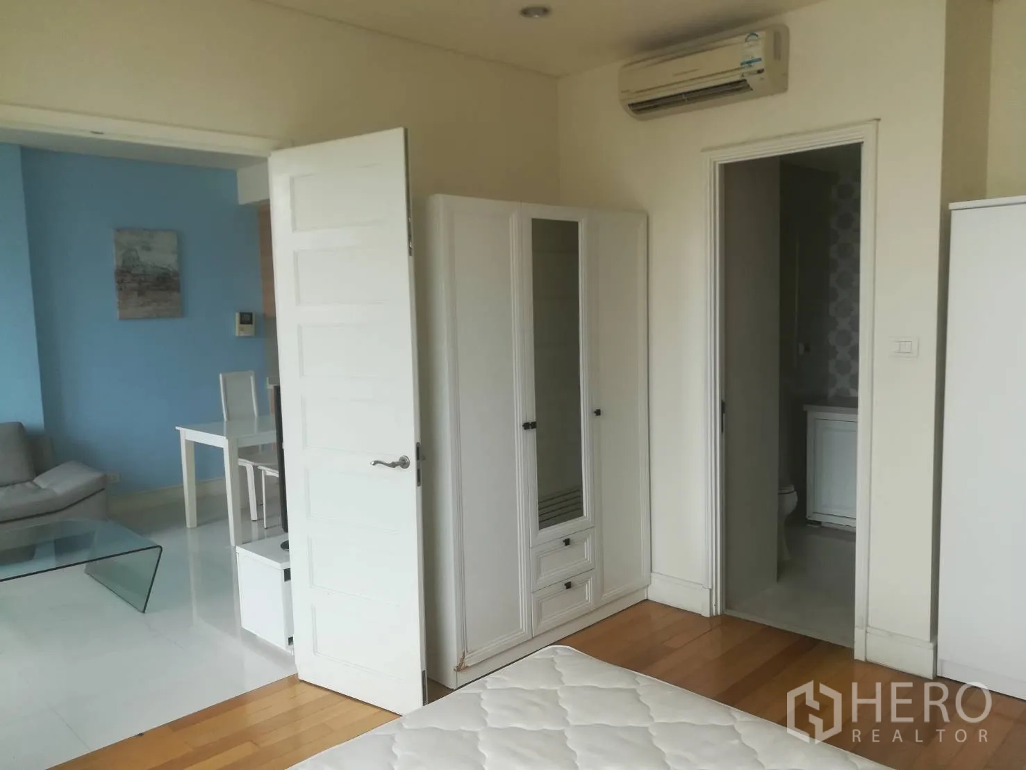 公寓 出售在Khlong Toei, Bangkok - 从卧室望向客厅，木地板、衣柜与套间入口。