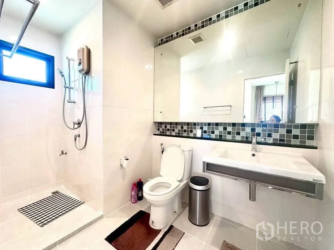Detached House for rent in Bang Kapi, Bangkok - Bathroom with walk-in shower, large mirror and white fixtures.