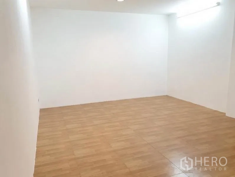 ทาวน์เฮาส์ ให้เช่าหรือขายในChatuchak, Bangkok - ห้องว่างขนาดใหญ่ พื้นลามิเนตลายไม้และผนังสีขาวสว่าง.