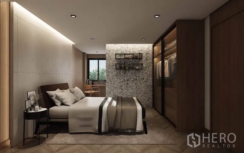 Detached House for rent in Watthana, Bangkok - Secondary bedroom with textured feature wall, built-in wardrobes, and a work desk by the window.