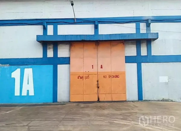 工厂 出租在Phra Pradaeng, Samut Prakan - 1A号工业单元外立面，宽大金属推拉门与充裕装卸区。