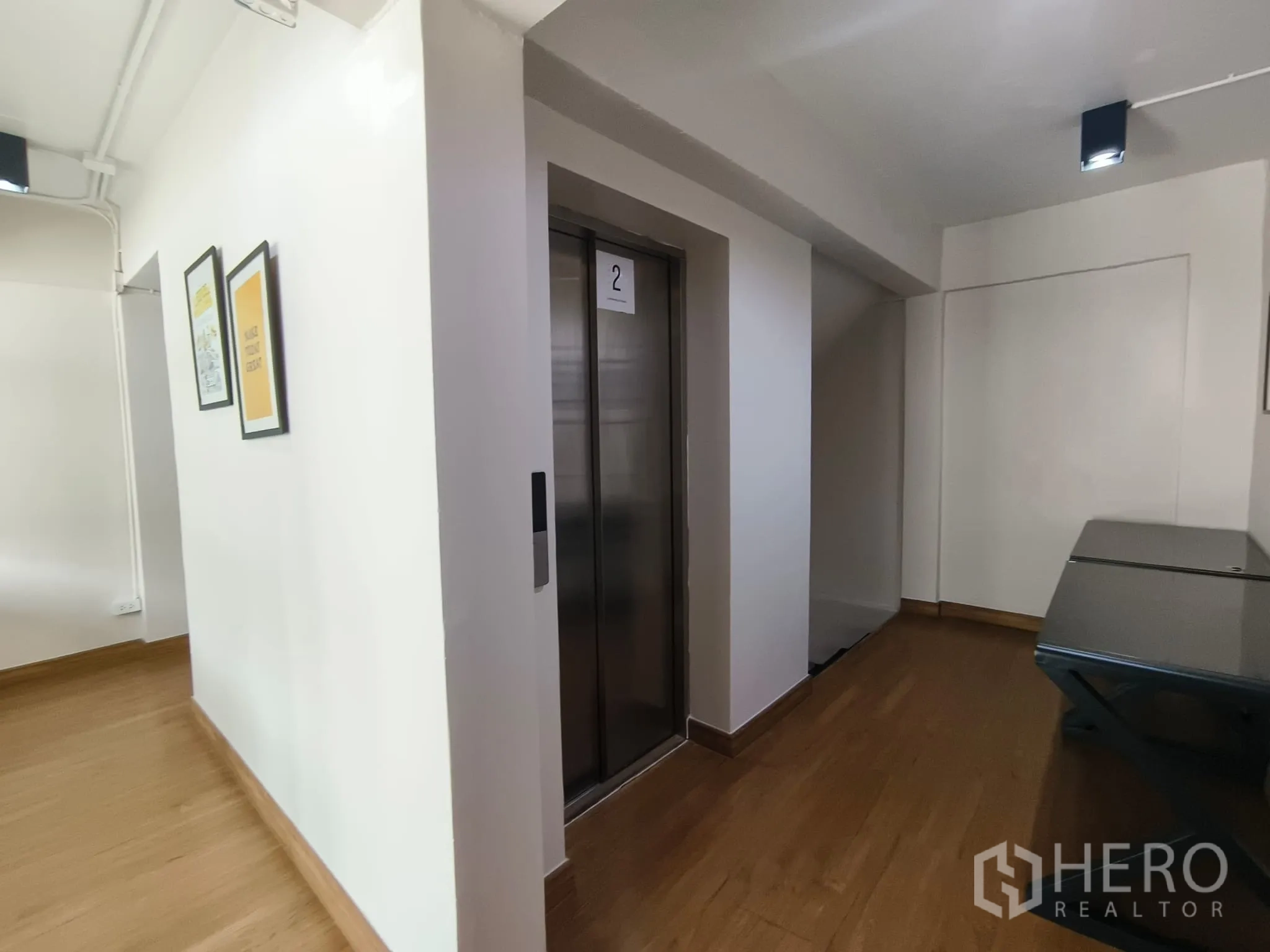 ตึกแถว for rent in Watthana, Bangkok - โถงลิฟต์พร้อมประตูลิฟต์ โปสเตอร์กรอบ และพื้นไม้.