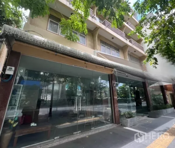 อาคารพาณิชย์ ให้เช่าในWatthana, Bangkok - หน้ากระจกยาวตลอดแนวของร้าน ภายใต้ร่มเงาต้นไม้ริมถนน.