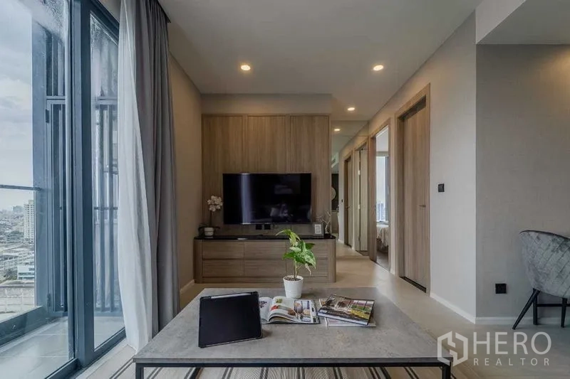 คอนโด ให้เช่าในPathum Wan, Bangkok - ห้องนั่งเล่นมีตู้วางทีวี ประตูกระจกบานเลื่อน และวิวเมืองไกล