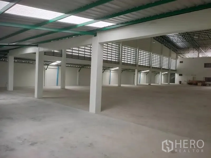 Factory for rent or sale in Bang Phli, Samut Prakan - Expansive warehouse floor under a steel roof with side loading doors.