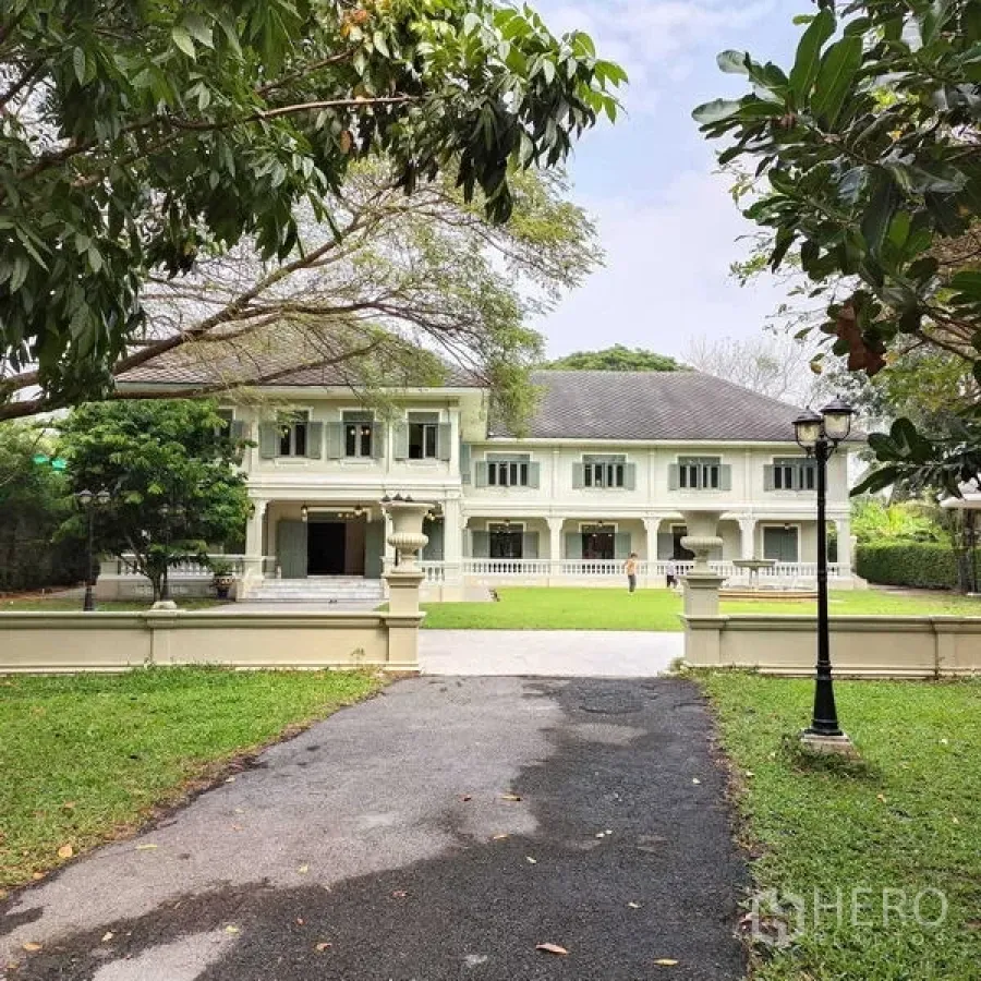 Detached House for rent or sale in Krathum Baen, Samut Sakhon - Stately front facade of the residence framed by mature trees.