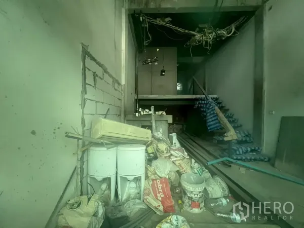 店屋 出售 - 一层室内毛坯状态，堆放建材与裸露线路，带部分夹层。