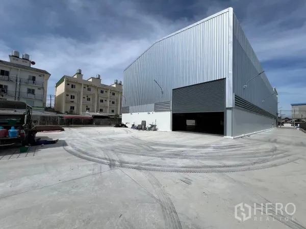 货栈 出租在Bang Sao Thong, Samut Prakan - 新建金属板仓库外观，超大卷闸门与宽阔混凝土堆场，位于邦绍通北榄府。