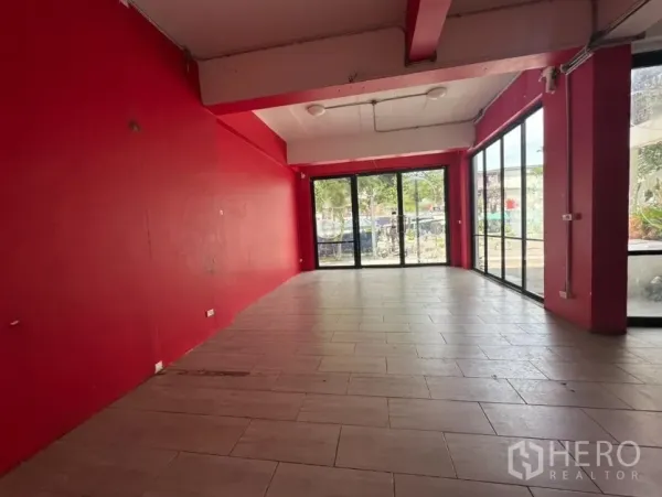 零售空间 出租在Khlong Toei, Bangkok - 纵深店铺空间，红色墙面与宽幅玻璃门面。