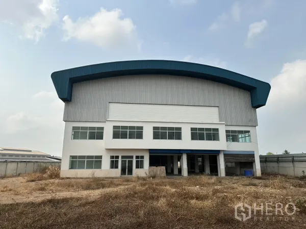 工厂 出租在Pak Kret, Nonthaburi - 工厂正立面，办公室窗墙与大型卷闸门入口。