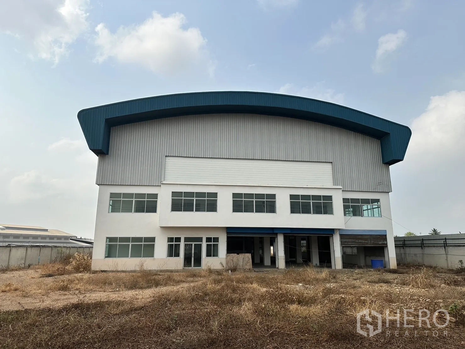 工厂 出租在Pak Kret, Nonthaburi - 工厂正立面，办公室窗墙与大型卷闸门入口。